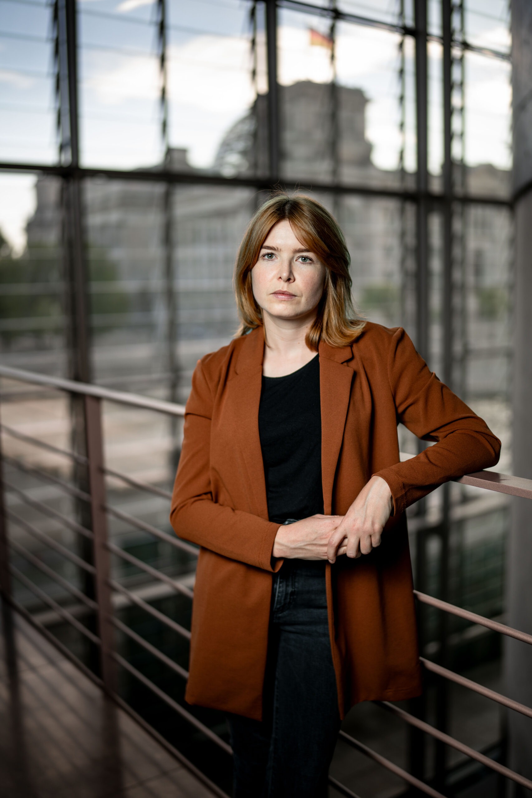 Marlene Schönberger lehnt an einem Geländer und blickt ernst in die Kamera.