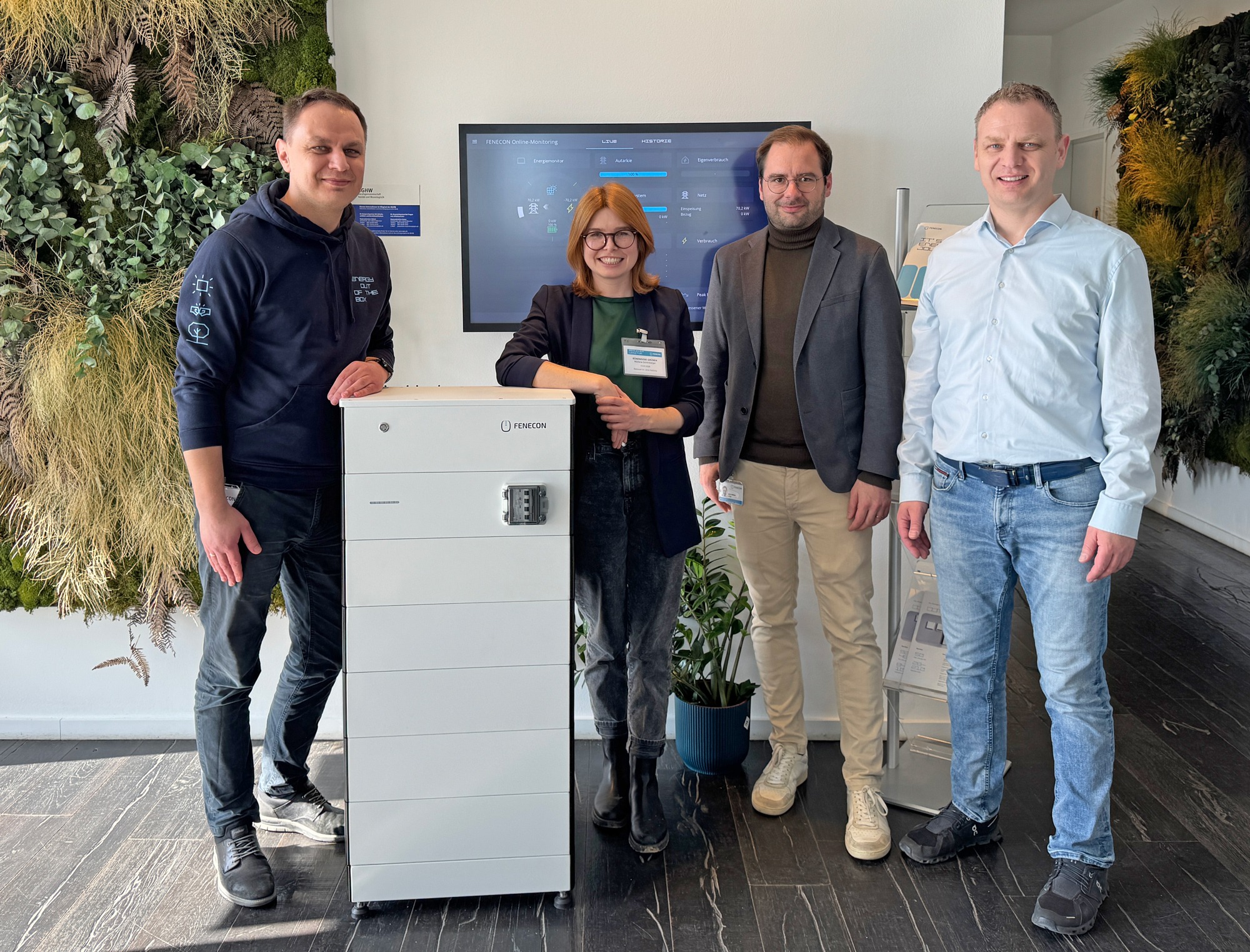 Eine Frau und 3 Männer stehen frontal zu Kamera lächeln freundlich.